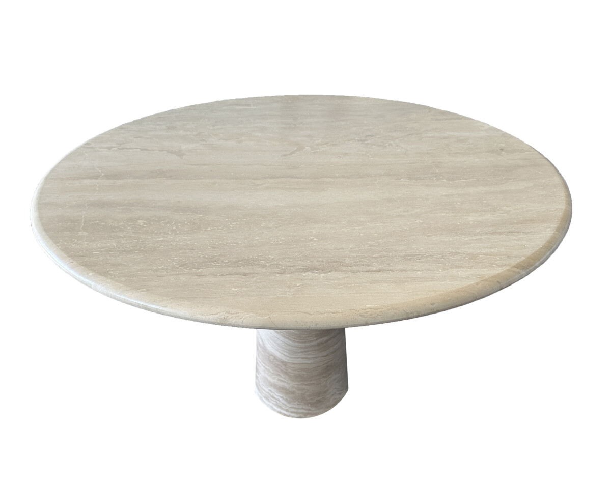 Round travertine dining table with a smooth beige surface and a cylindrical pedestal base, evoking a minimalist and elegant design.